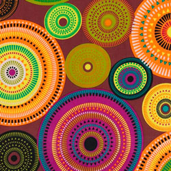 Tela con dibujos geométricos de círculos de diferentes colores en tonos tierra. En este estampado predominan los colores naranja y marrón.